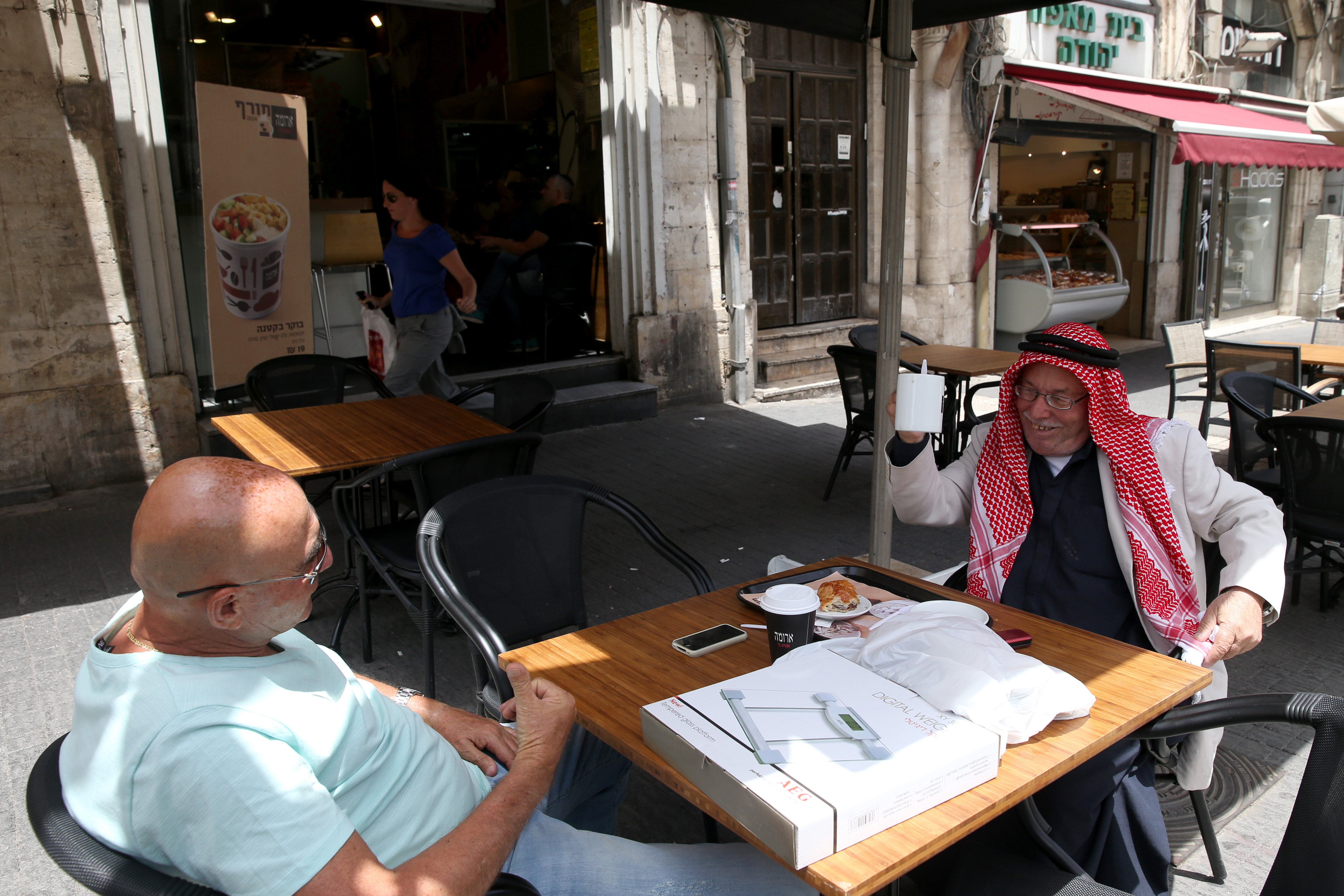 Actual coexistence, with all its pleasures and flaws. A Jew and a Muslim sitting together in a coffee shop. Photo: Nati Shohat/Flash 90