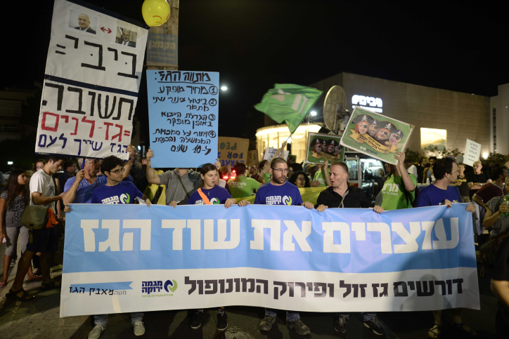 Israelis holding placards as they protest march in Tel Aviv on July 4, 2015, against the decision by the Israeli government committee approving a plan to allow Americas Noble Energy and Israels Delek Group access to Israels Tamar and Leviathan offshore natural gas reserves. Photo by Tomer Neuberg/Flash90 *** Local Caption *** ????? ??? ?? ?? ???? ?????